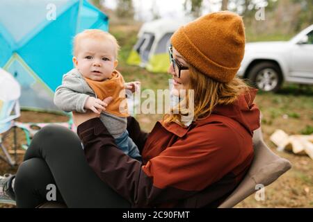 USA, Utah, Uninta Wasatch cache National Forest, mère Holding son (6-11 mois) en camping Banque D'Images