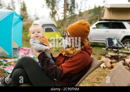 USA, Utah, Uninta Wasatch cache National Forest, mère Holding son (6-11 mois) en camping Banque D'Images