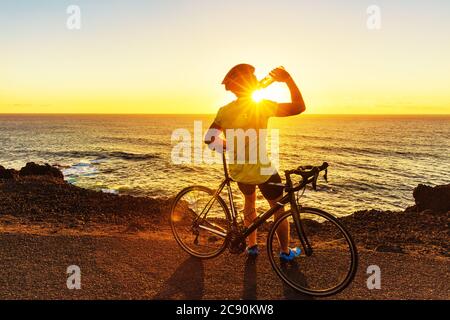 Athlète cycliste homme buvant de l'eau à vélo Banque D'Images