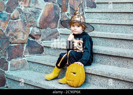 Halloween squelette enfant. Enfant insouciant. Enfants trick ou traiter. Les enfants jouent à l'extérieur. Petit garçon drôle sur les marches. Banque D'Images