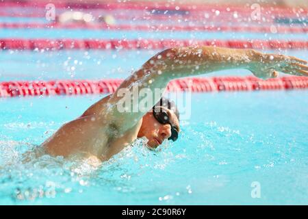 Entraînement de triathlon en forme d'athlète dans la voie de la piscine au stade extérieur. Nageur homme natation en été. Sports et fitness les gens de style de vie Banque D'Images