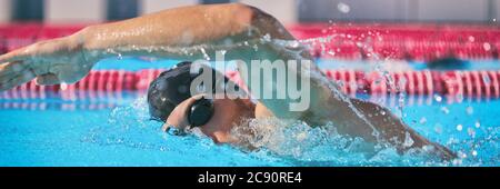 SPORT et FITNESS concept sport athlète natation en piscine entraînement cardio faire la technique libre pour la course de vitesse. Homme nageur en intérieur Banque D'Images
