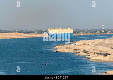 El Qantara, Egypte - 14 novembre 2019: Gros véhicules navire porteur Grand Sapphire passant par le canal de Suez dans la brume sablonneuse en Egypte. Banque D'Images