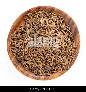 Graines de caraway dans bol en bois vue de dessus isolée sur blanc. Banque D'Images