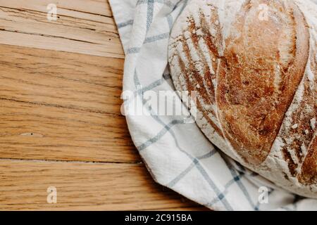 Pain de pâte à l'écuyer fait maison refroidi sur une serviette de thé qui est sur une planche à découper en bois avec de la place pour la copie Banque D'Images