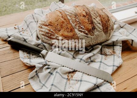 Pain à la pâte à sucre maison refroidi sur une serviette de thé qui est sur une planche à découper en bois, des fleurs sauvages séchées sont arrosées autour Banque D'Images