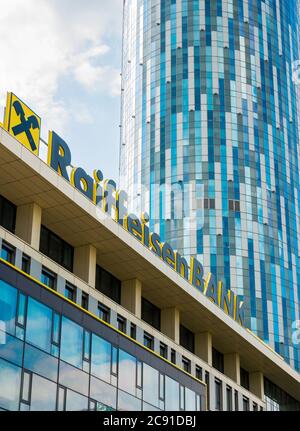 Bucarest/Roumanie - 07.18.2020: Logo de la banque Raiffeisen sur un immeuble de bureaux avec un gratte-ciel en arrière-plan, à Bucarest. Banque D'Images
