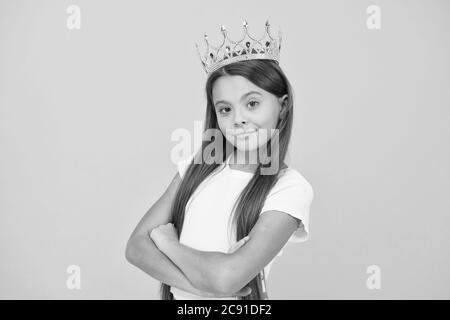 Jeune perfectionniste. luxe et succès. Petite fille égoïste portent la couronne d'or. Petite princesse. Se sentir championne. Bonne enfance. Bonne motivation concept. Elle est grand patron. Fière de sa récompense. Banque D'Images