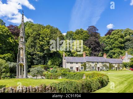 Le Bristol High Cross et une rangée de cottages traditionnels en pierre sur Church Lawn, Stourton, un petit village près de Stourhead, Wiltshire, au sud-ouest de l'Angleterre Banque D'Images