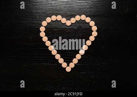 Plan d'ange élevé d'une pilule orange claire formée en la forme d'un cœur Banque D'Images