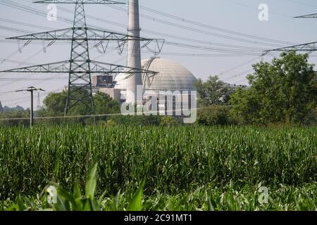 Le dôme du réacteur d'une centrale nucléaire. Et devant elle une cheminée, des lignes électriques et un champ de maïs. Banque D'Images