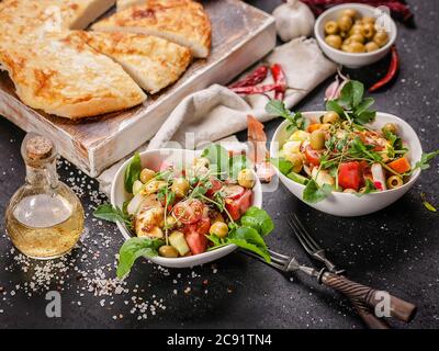 Deux portions de salade avec fromage halloumi grillé, tomates, poivrons, olives, arugula et tortilla au fromage. Plats diététiques méditerranéens Banque D'Images