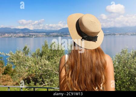 Belle femme touristique avec chapeau profitant de la vue sur le lac de Garde depuis Sirmione, Italie Banque D'Images