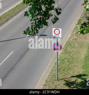 Vue en grand angle d'un panneau de signalisation indiquant l'entrée d'un zone environnementale à côté d'une rue vide Banque D'Images