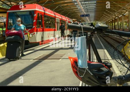 Zermatt, Suisse - 20 juillet 2020 : masque suspendu au guidon d'un vélo dans une gare Banque D'Images