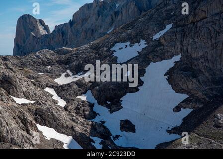 Les marcheurs traversent un bord de neige dans les montagnes de Picos de Europa, Espagne Banque D'Images