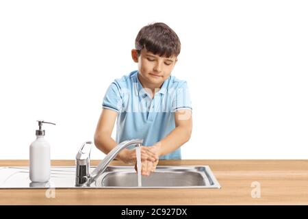 Portrait d'un enfant se lavant les mains dans un évier en acier inoxydable isolé sur fond blanc Banque D'Images