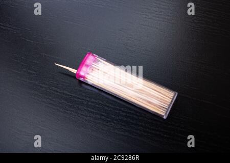Cure-dents dans une boîte en plastique sur une table en bois Banque D'Images