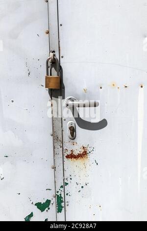 Porte en métal gris fermée par un cadenas Banque D'Images