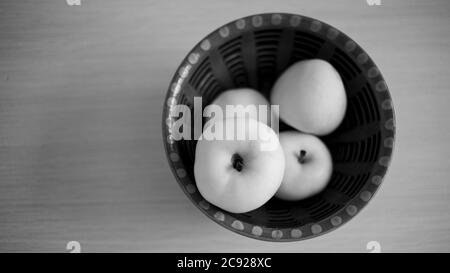 Pommes mûres dans un bol en argile sur la table. Vue de dessus. PHOTO BW. Banque D'Images