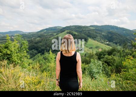 Jeune femme profitant de la vue sur une chaîne de montagnes Banque D'Images