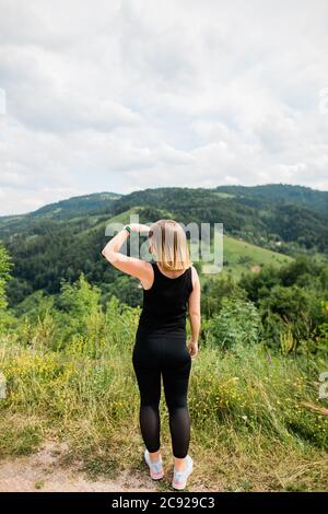 Jeune femme profitant de la vue sur une chaîne de montagnes Banque D'Images