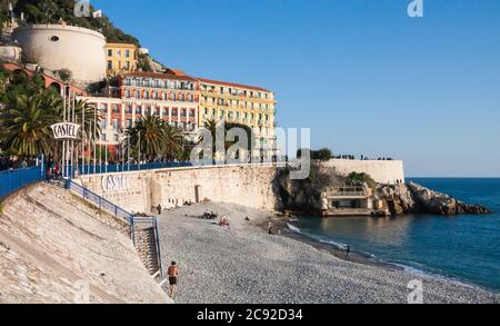 Nice, France février 6 2011: Plage de Castel par une belle journée d'hiver avec des personnes marchant sur la promenade. Nice est une ville touristique populaire dans le sud de Banque D'Images