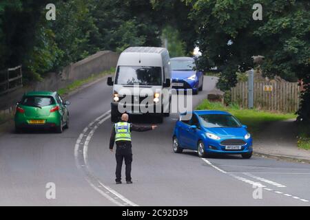 Un policier détourne la circulation de la scène d'un accident sur le chemin Wakefield à Swillington. Banque D'Images