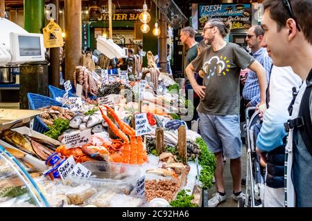 Personnes achetant des fruits de mer à un Sall dans Borough Market, Londres, Angleterre. Banque D'Images