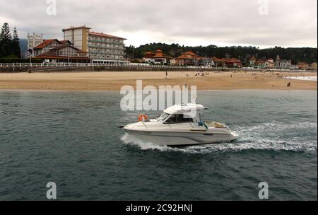 Petit yacht blanc à moteur qui revient à Ribadesella Asturias Espagne le long de la rivière Sella Banque D'Images