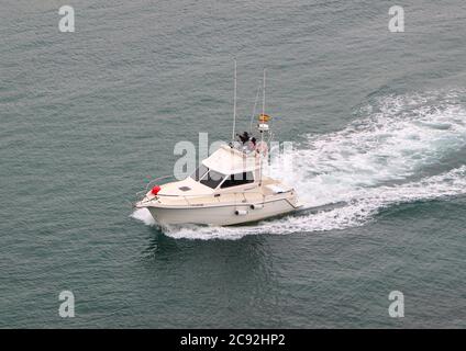 Petit yacht blanc à moteur qui revient à Ribadesella Asturias Espagne le long de la rivière Sella Banque D'Images