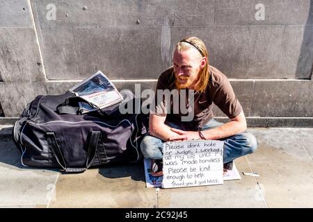 Un homme sans-abri dans les rues de Londres avec UN panneau demandant de ne pas être jugé, Borough High Street, Londres, Angleterre. Banque D'Images