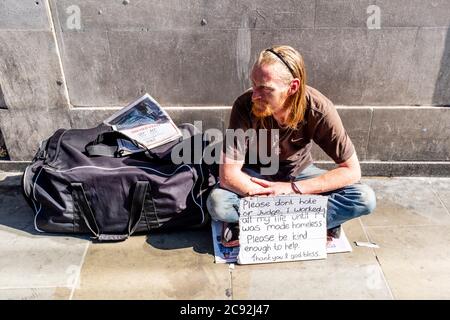 Un homme sans-abri dans les rues de Londres avec UN panneau demandant de ne pas être jugé, Borough High Street, Londres, Angleterre. Banque D'Images