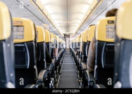 Couloir vide dans l'avion avec tous les passagers assis. Banque D'Images