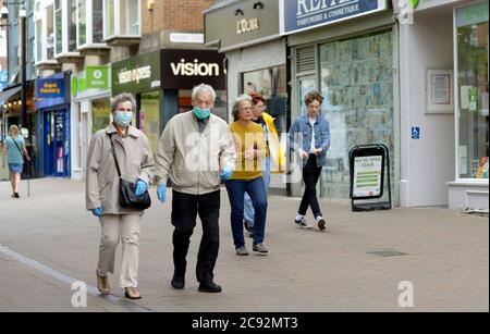 Couple de personnes âgées dans des masques de visage avec des gants en latex, hors shopping après verrouillage. Banque D'Images