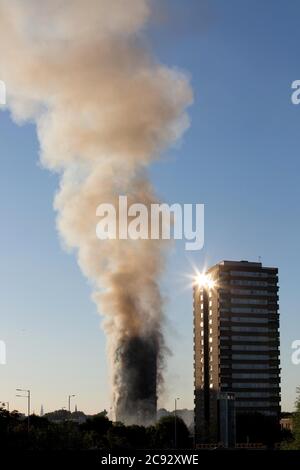 De la fumée s'élève à l'incendie de la Grenfell Tower, un immeuble de 24 étages faisant partie du Lancaster West Estate à North Kensington, Londres, Royaume-Uni. L'incendie a été déclenché tôt le matin par un réfrigérateur-congélateur défectueux au quatrième étage. Il s'étend rapidement à l'extérieur du bâtiment, par le revêtement extérieur et l'isolation. L'incendie a causé 72 morts, dont ceux de deux victimes qui sont plus tard décédées à l'hôpital. Plus de 70 autres personnes ont été blessées et 223 personnes ont échappé. C'était le feu structurel le plus meurtrier du Royaume-Uni depuis 1988 et le pire incendie résidentiel britannique depuis la Seconde Guerre mondiale Banque D'Images