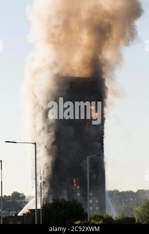 De la fumée s'élève à l'incendie de la Grenfell Tower, un immeuble de 24 étages faisant partie du Lancaster West Estate à North Kensington, Londres, Royaume-Uni. L'incendie a été déclenché tôt le matin par un réfrigérateur-congélateur défectueux au quatrième étage. Il s'étend rapidement à l'extérieur du bâtiment, par le revêtement extérieur et l'isolation. L'incendie a causé 72 morts, dont ceux de deux victimes qui sont plus tard décédées à l'hôpital. Plus de 70 autres personnes ont été blessées et 223 personnes ont échappé. C'était le feu structurel le plus meurtrier du Royaume-Uni depuis 1988 et le pire incendie résidentiel britannique depuis la Seconde Guerre mondiale Banque D'Images