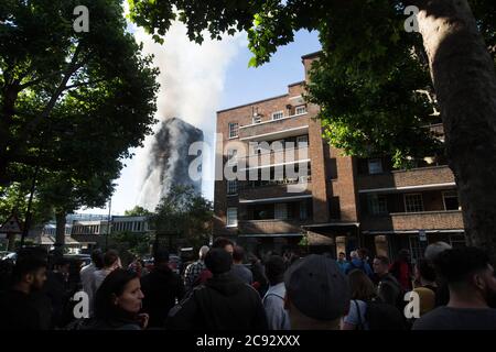 De la fumée s'élève à l'incendie de la Grenfell Tower, un immeuble de 24 étages faisant partie du Lancaster West Estate à North Kensington, Londres, Royaume-Uni. L'incendie a été déclenché tôt le matin par un réfrigérateur-congélateur défectueux au quatrième étage. Il s'étend rapidement à l'extérieur du bâtiment, par le revêtement extérieur et l'isolation. L'incendie a causé 72 morts, dont ceux de deux victimes qui sont plus tard décédées à l'hôpital. Plus de 70 autres personnes ont été blessées et 223 personnes ont échappé. C'était le feu structurel le plus meurtrier du Royaume-Uni depuis 1988 et le pire incendie résidentiel britannique depuis la Seconde Guerre mondiale Banque D'Images