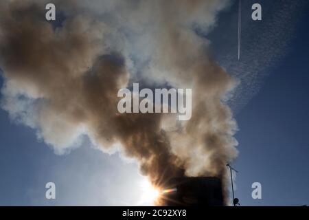 De la fumée s'élève à l'incendie de la Grenfell Tower, un immeuble de 24 étages faisant partie du Lancaster West Estate à North Kensington, Londres, Royaume-Uni. L'incendie a été déclenché tôt le matin par un réfrigérateur-congélateur défectueux au quatrième étage. Il s'étend rapidement à l'extérieur du bâtiment, par le revêtement extérieur et l'isolation. L'incendie a causé 72 morts, dont ceux de deux victimes qui sont plus tard décédées à l'hôpital. Plus de 70 autres personnes ont été blessées et 223 personnes ont échappé. C'était le feu structurel le plus meurtrier du Royaume-Uni depuis 1988 et le pire incendie résidentiel britannique depuis la Seconde Guerre mondiale Banque D'Images