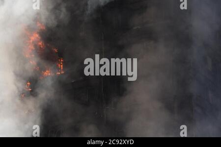 De la fumée s'élève à l'incendie de la Grenfell Tower, un immeuble de 24 étages faisant partie du Lancaster West Estate à North Kensington, Londres, Royaume-Uni. L'incendie a été déclenché tôt le matin par un réfrigérateur-congélateur défectueux au quatrième étage. Il s'étend rapidement à l'extérieur du bâtiment, par le revêtement extérieur et l'isolation. L'incendie a causé 72 morts, dont ceux de deux victimes qui sont plus tard décédées à l'hôpital. Plus de 70 autres personnes ont été blessées et 223 personnes ont échappé. C'était le feu structurel le plus meurtrier du Royaume-Uni depuis 1988 et le pire incendie résidentiel britannique depuis la Seconde Guerre mondiale Banque D'Images