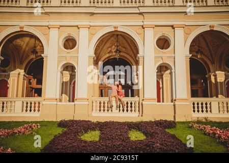 ODESSA, UKRAINE - 15 OCTOBRE 2014 : couple aimant heureux assis à l'extérieur au balcon de l'Opéra d'Odessa. L'homme pointe du doigt vers quelque chose Banque D'Images