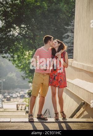 ODESSA, UKRAINE - 15 OCTOBRE 2014 : un jeune couple heureux qui s'embrasse et embrasse en plein air l'été en buvant du Pepsi froid à partir de bouteilles de verre avec de la paille Banque D'Images