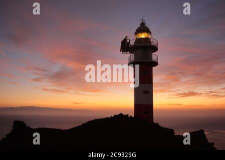 Buenavista del Norte, Santa Cruz de Tenerife/Espagne; 10 octobre 2011. Coucher de soleil au phare de Punta de Teno, avec l'île de la Gomera dans l'arrière-gro Banque D'Images