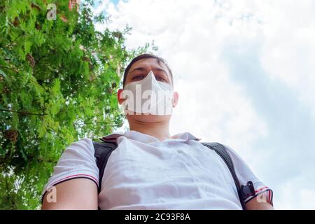 Portrait du visage de jeune homme avec masque médical se tient à la nature. Gros plan, virus corona Banque D'Images