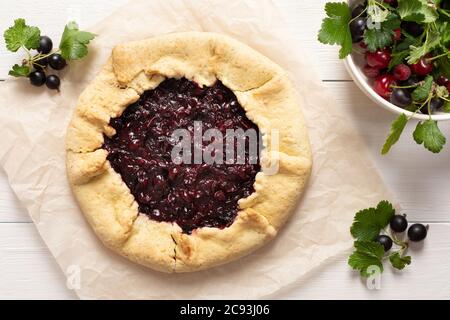 Tarte ouverte de pâte à croûte courte avec cassis, délicieuse galette de jostaberry sur fond blanc Banque D'Images