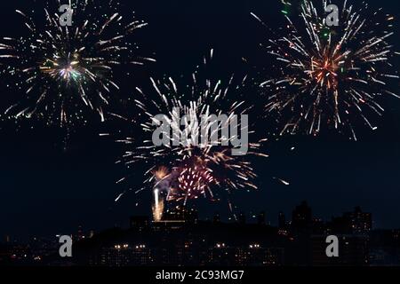 Des feux d'artifice à la fusée Spider explosent au-dessus des gratte-ciel du nord de manhattan, vus depuis un toit de la ville de New york le 4 juillet 2020 contre un ciel nocturne Banque D'Images