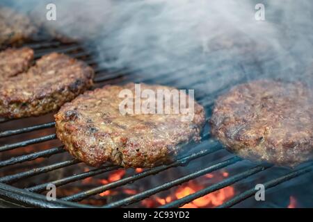 Steaks de viande juteuse cuits au charbon de bois sur un support en fil de fer. Viande cuite au feu à l'air libre. Mise au point sélective. Gros plan. Banque D'Images