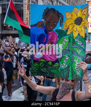 Black Womens/Womxn March Black Lives Matter Protest - Black Girl arrosoir fleurs signe avec drapeau Banque D'Images