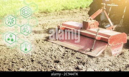 Le tracteur équipé d'une fraiseuse se desserre, grince et mélange les hayons et les hexagones avec des innovations. Science de l'agronomie. Amélioration de la qualité et du rendement gro Banque D'Images