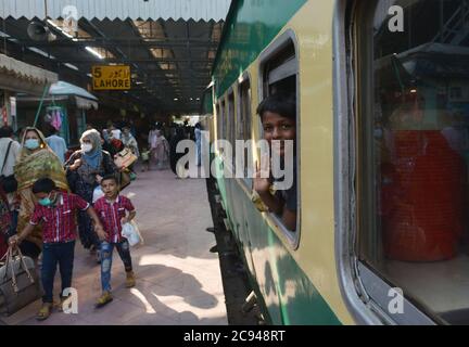 Lahore, Pakistan. 28 juillet 2020. Les Pakistanais partent pour leur ville natale et leurs villages pour célébrer Eid al-Adha avec leur amour et les membres de leur famille » à la gare, tandis que le gouvernement du Punjab a annoncé un verrouillage complet dans le cadre de l'épidémie de virus corona avant Eid-ul-Azha du 28 juillet au 5 août à Lahore. (Photo de Rana Sajid Hussain/Pacific Press) crédit: Pacific Press Media production Corp./Alay Live News Banque D'Images